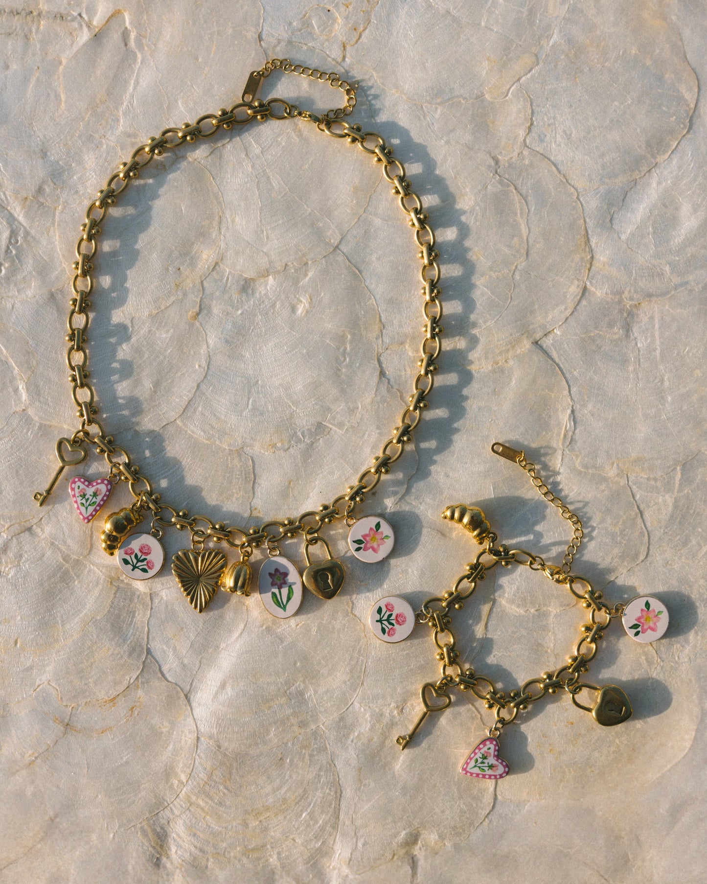 Gold bracelet with colorful charms on a stone surface
