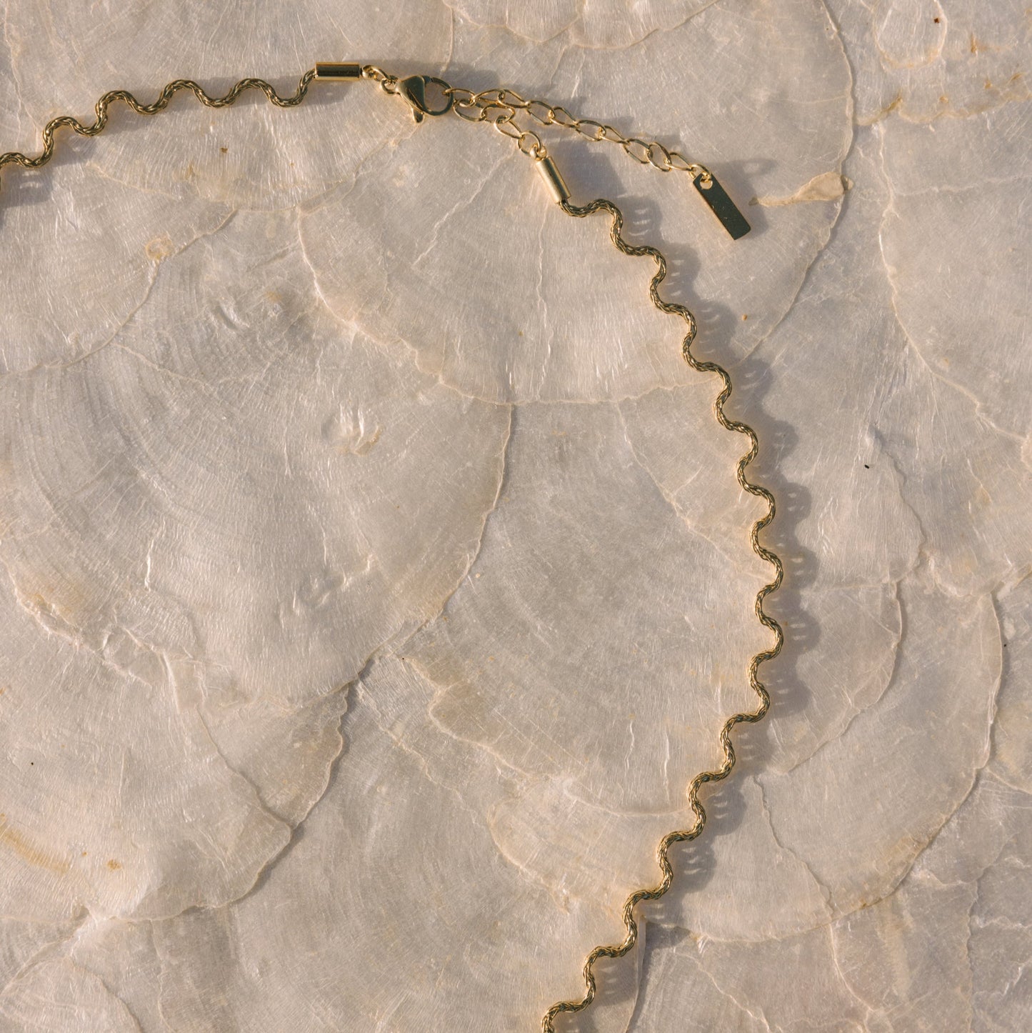 Gold chain necklace on a marble surface