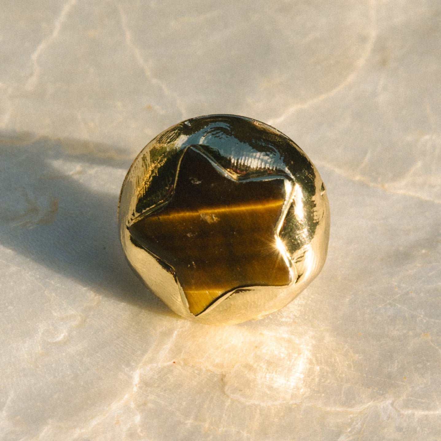 Gold-colored gemstone on a marble surface