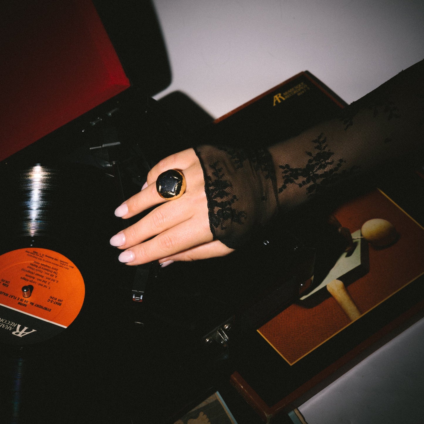 Hand holding a vinyl record with a dark background