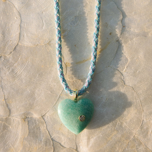 Necklace with a heart-shaped turquoise pendant on a stone surface