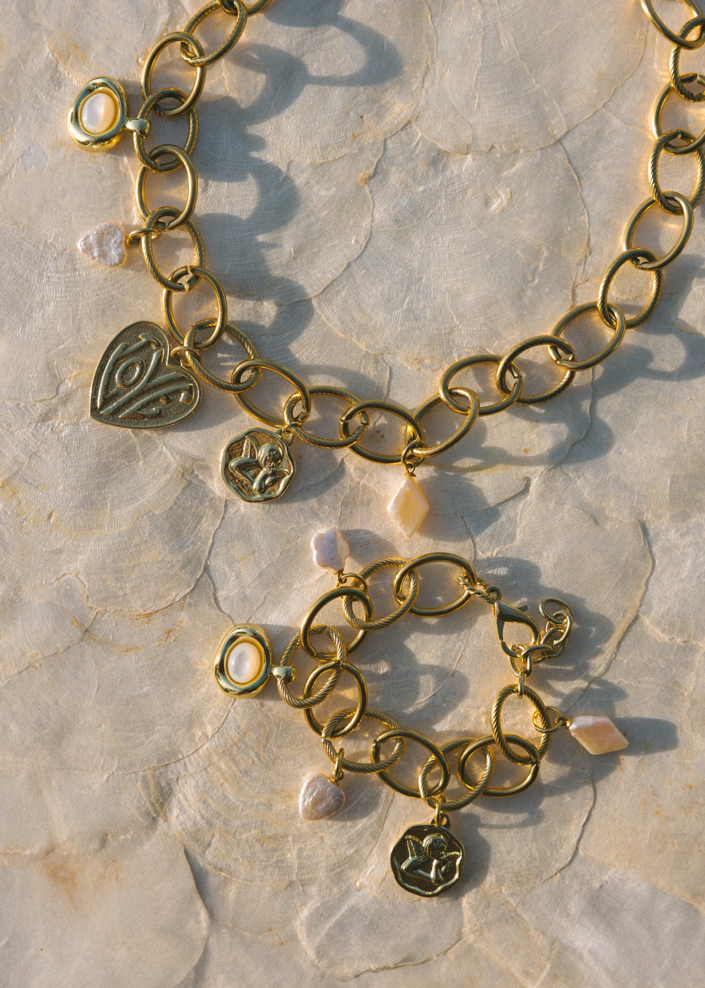 Gold bracelet with heart-shaped charms on a stone surface