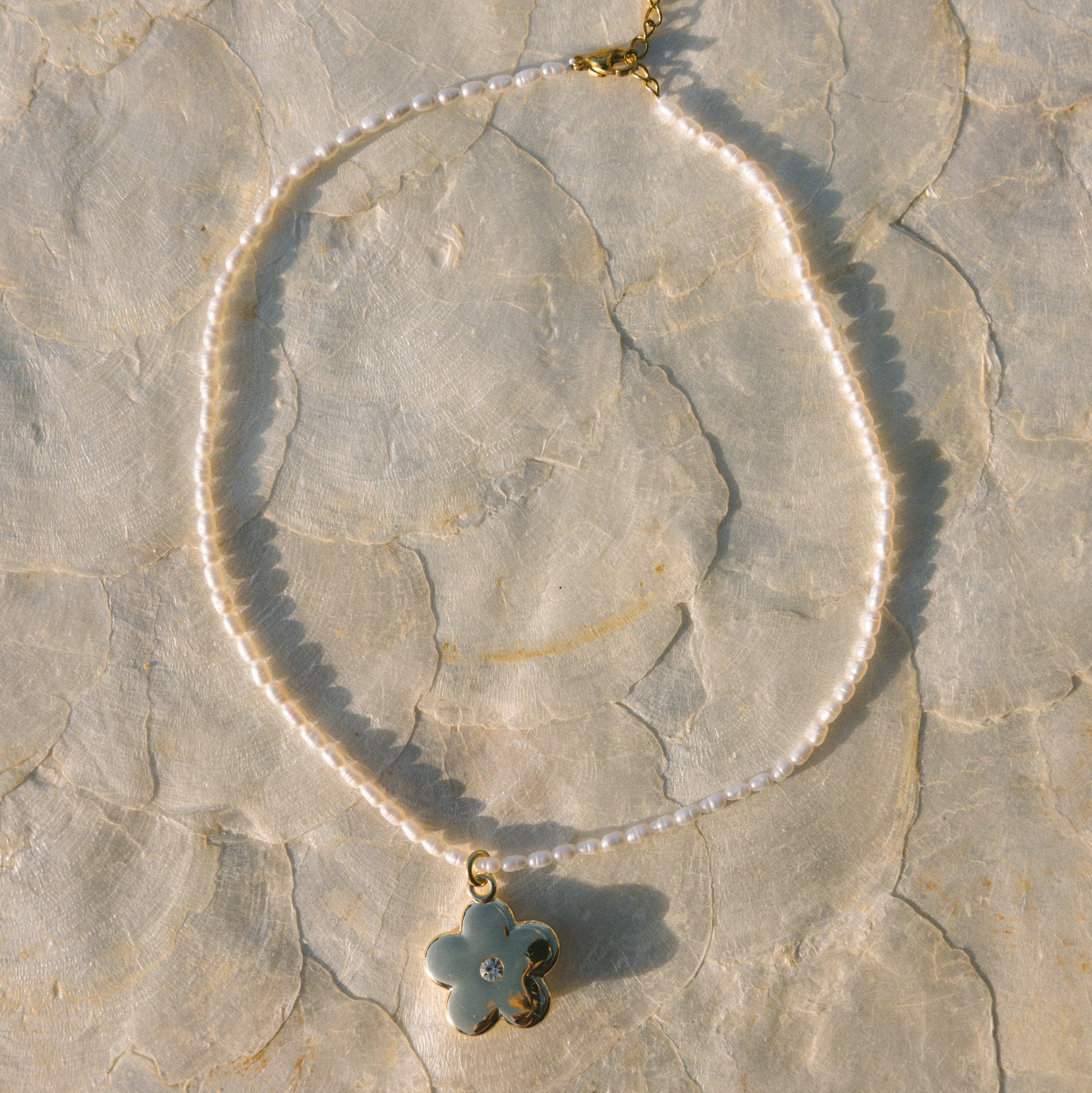 Bracelet with a clover-shaped charm on a stone surface