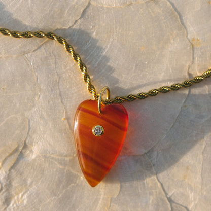 Necklace with a red heart-shaped pendant on a stone surface