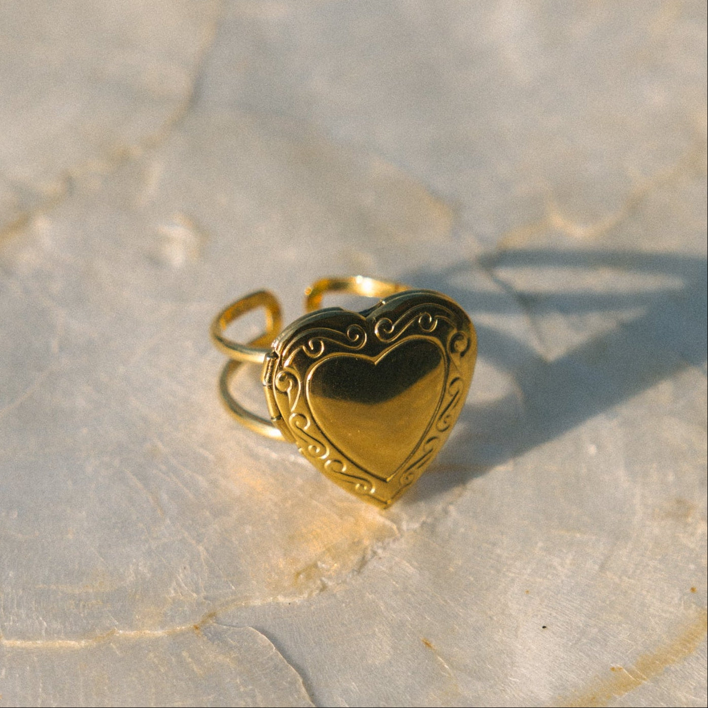 Gold heart-shaped ring on a textured stone surface