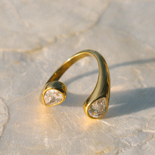 Gold ring with small diamonds on a light stone surface
