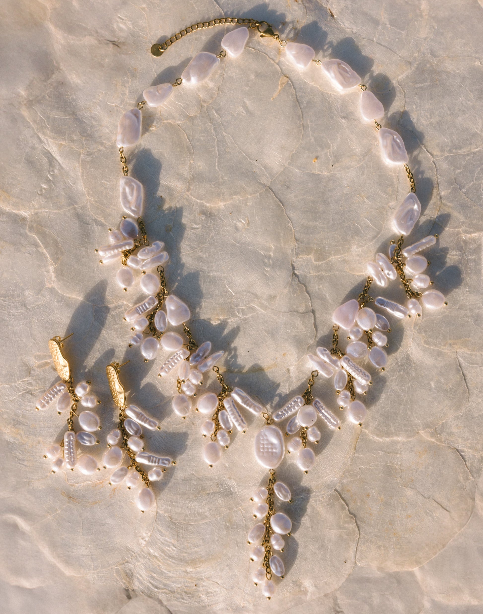 Necklace with pearls and gold accents on a textured stone surface