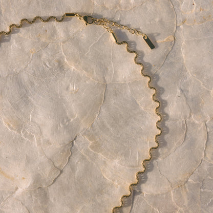 Gold chain necklace on a marble surface