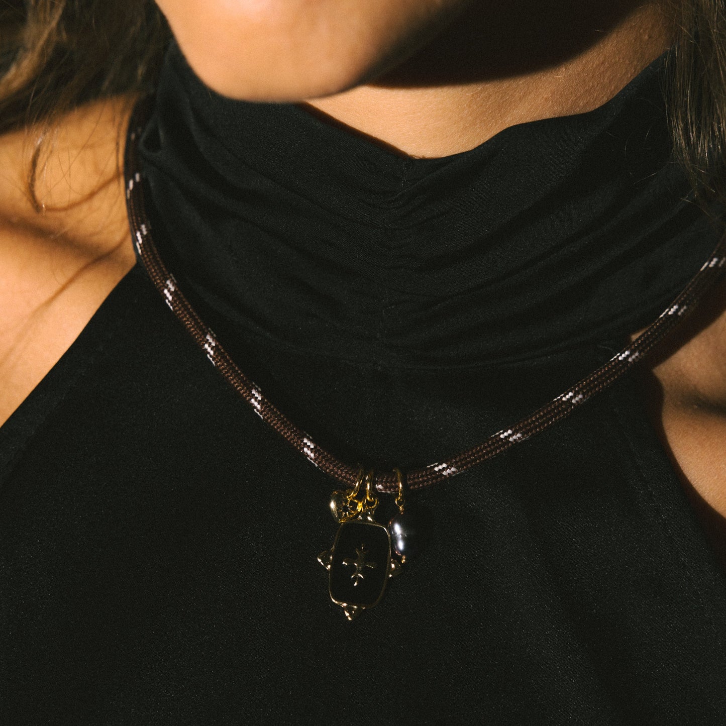 Necklace with a pendant worn by a person against a dark background