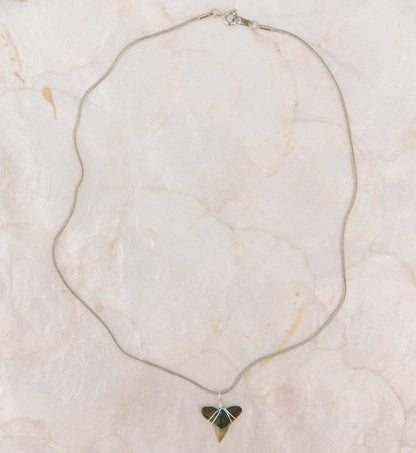 Necklace with a triangular pendant on a marble surface