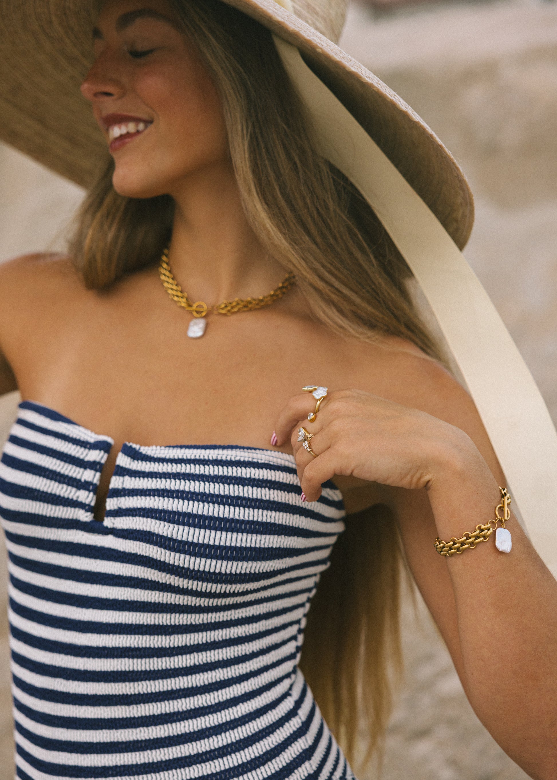 Woman wearing a striped dress and gold jewelry outdoors